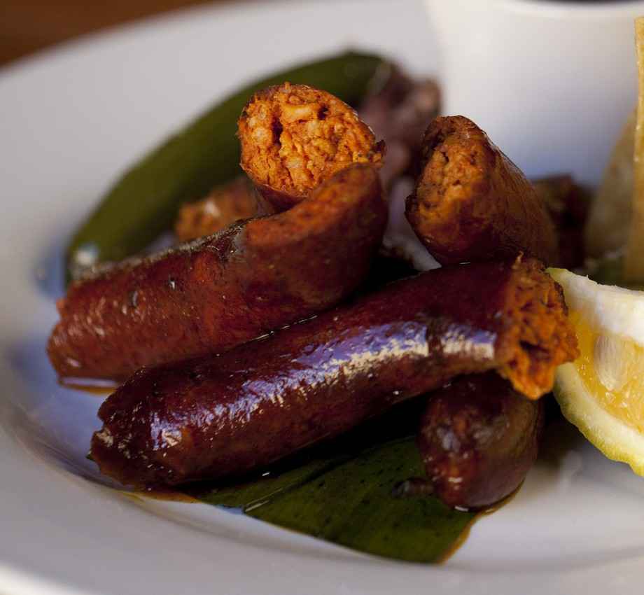 Several chorizo Mexican sausages on a plate with chilies.