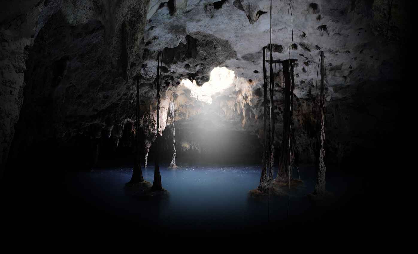 A view of the crystal clear blue water and sunlight shining in a Playa Del Carmen cenote.