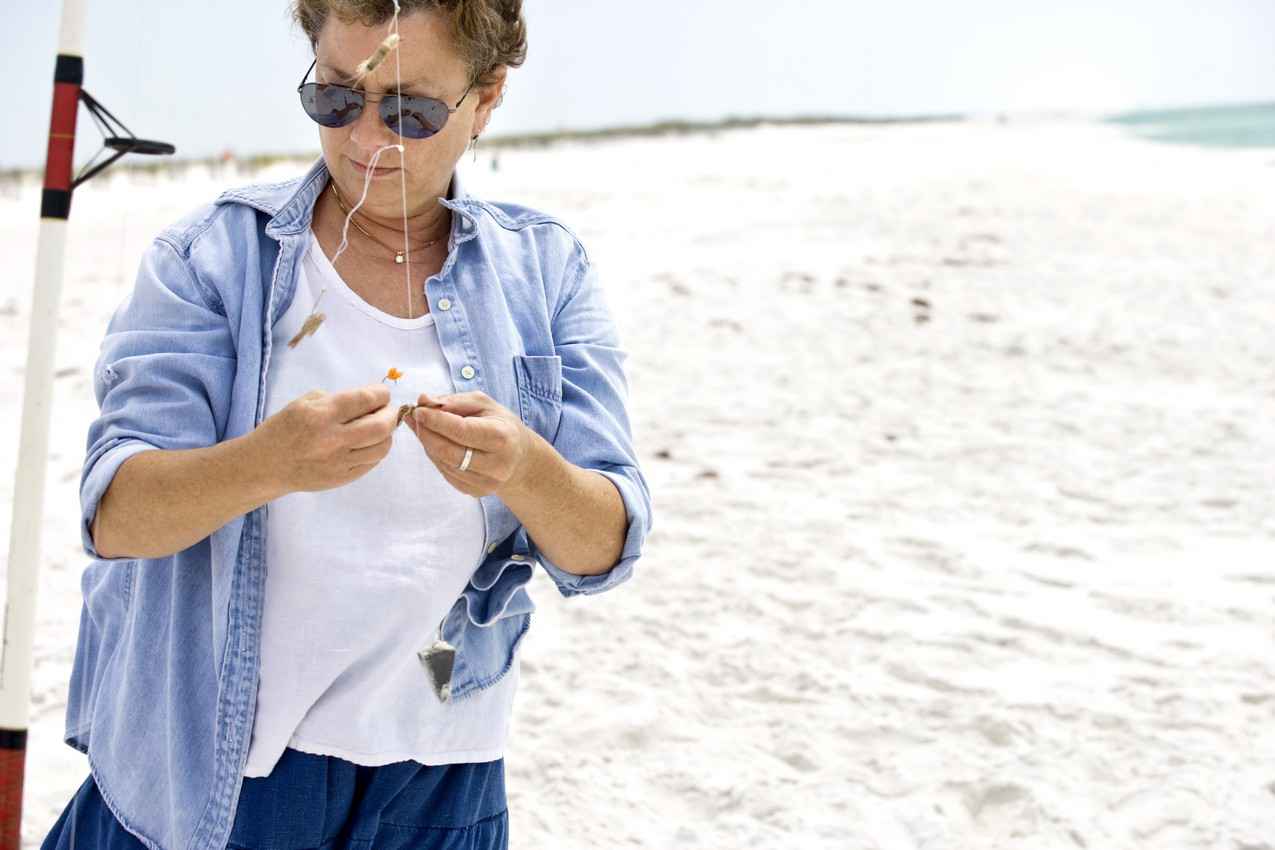 A woman tying a fly fishing knot.
