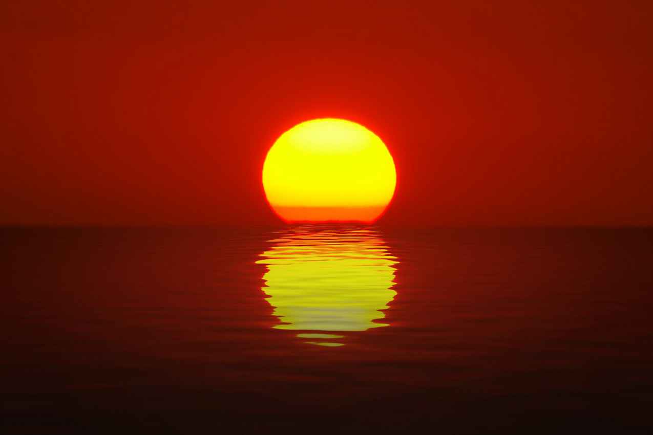 The sun setting and melting into the Caribbean Sea.
