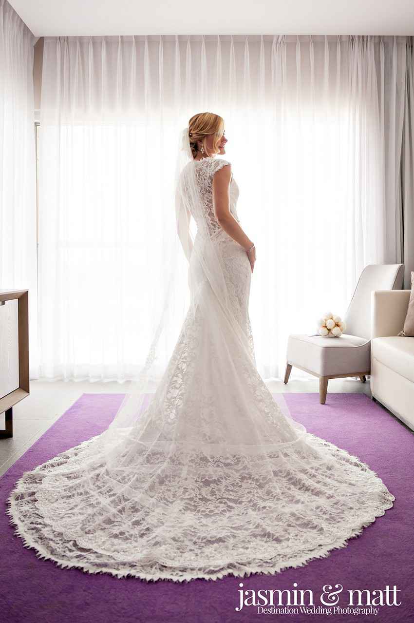 A bride showing off her wedding dress in resort or hotel room.