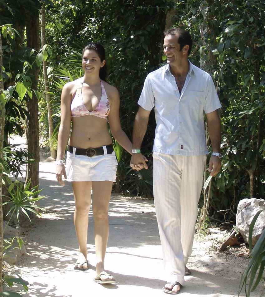 A man and a woman walking hand-in-hand during a jungle tour in Playa Del Carmen.