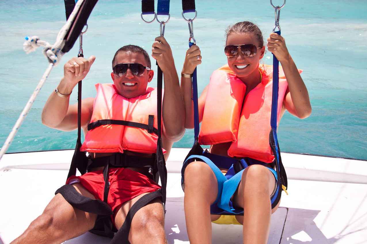 A newlywed couple preparing to go parasailing.