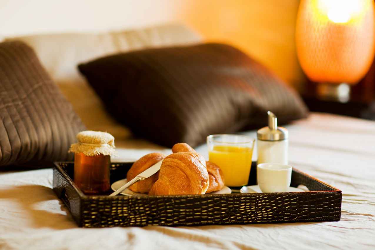 A delicious breakfast on a resort bed.