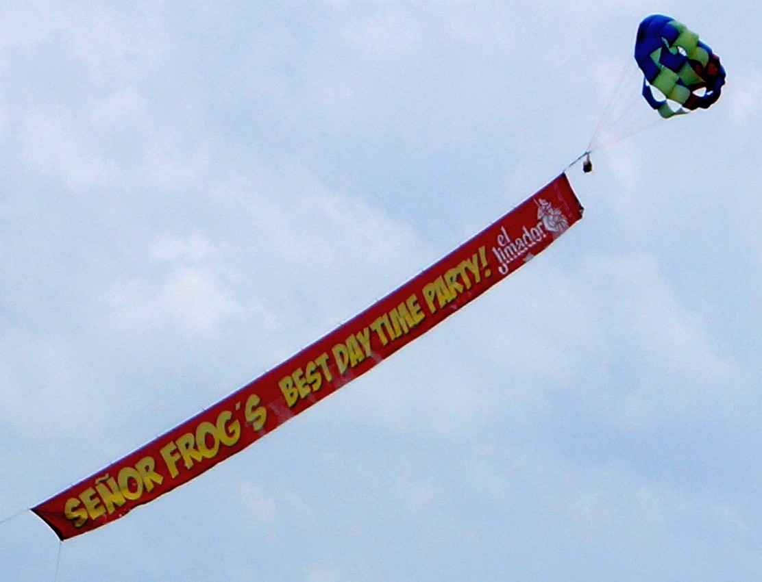 Senor Frogs airborne advertisement over the beach.