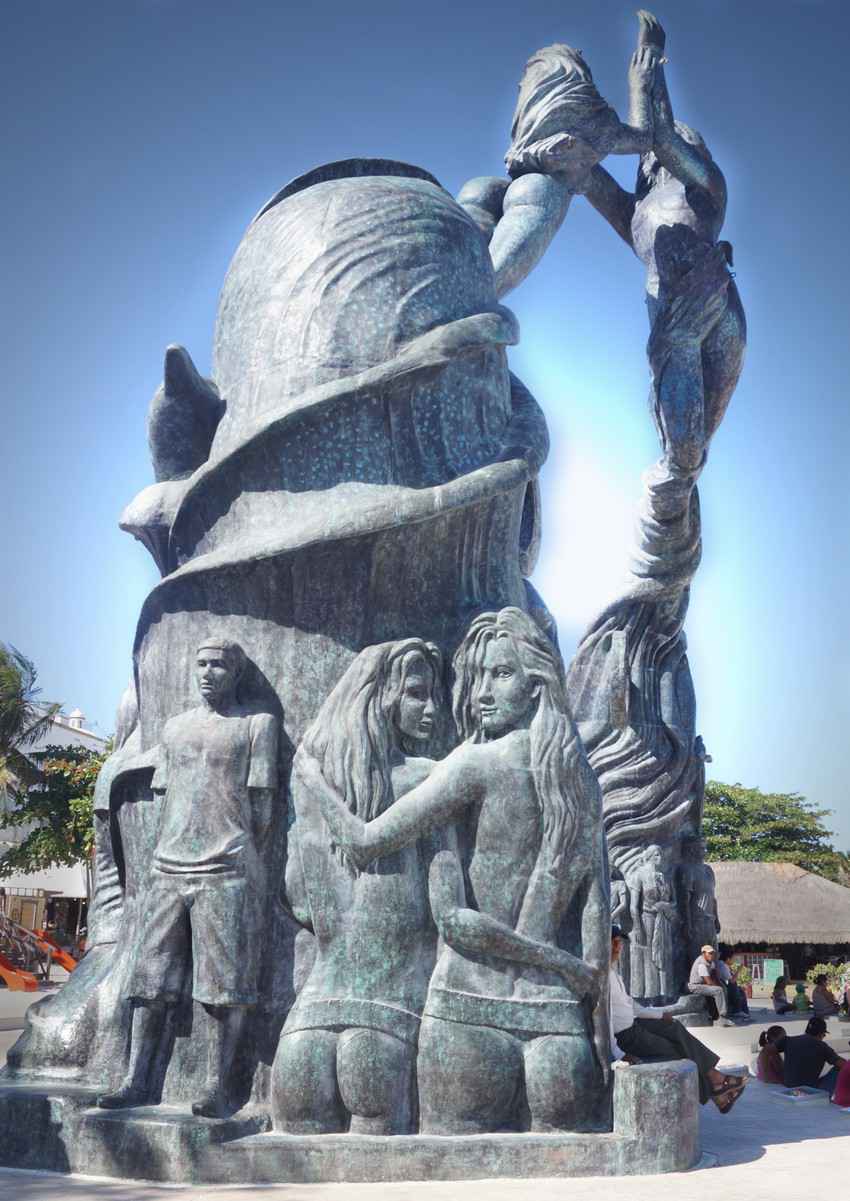 A side view of the statue that is on the beach in Playa Del Carmen featuring two women embracing.