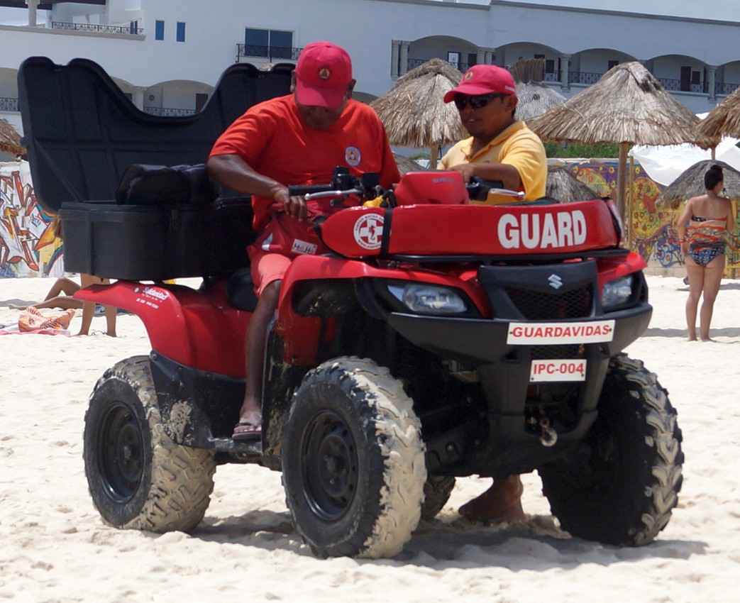 Two lifeguards riding an ATV on the beach in Playa Del Carmen.