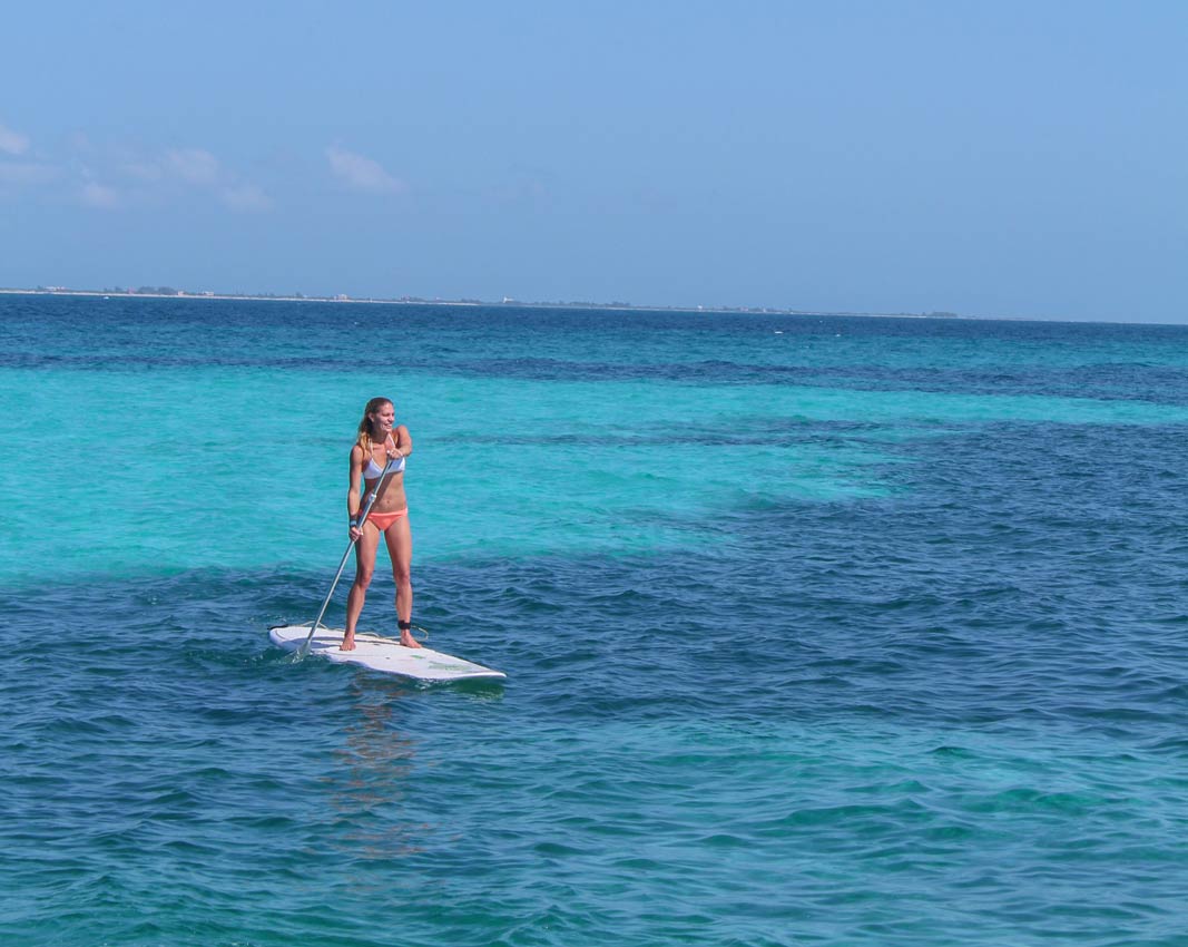 a-woman-paddle-boarding-as-one-of-the-activities-possible-on-a-playa-del-carmen-booze-cruise