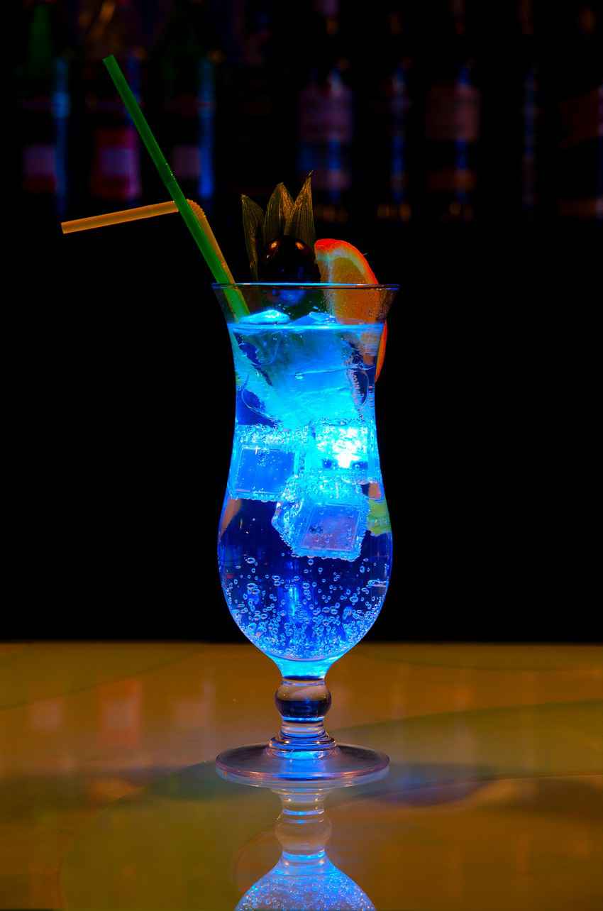A brightly lit cocktail on the bar.