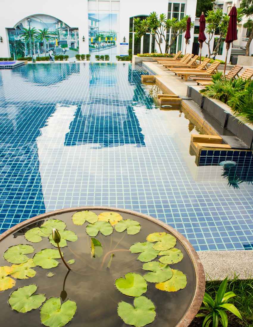 A large blue tiled swimming pool that is available for use by condo rental guests.