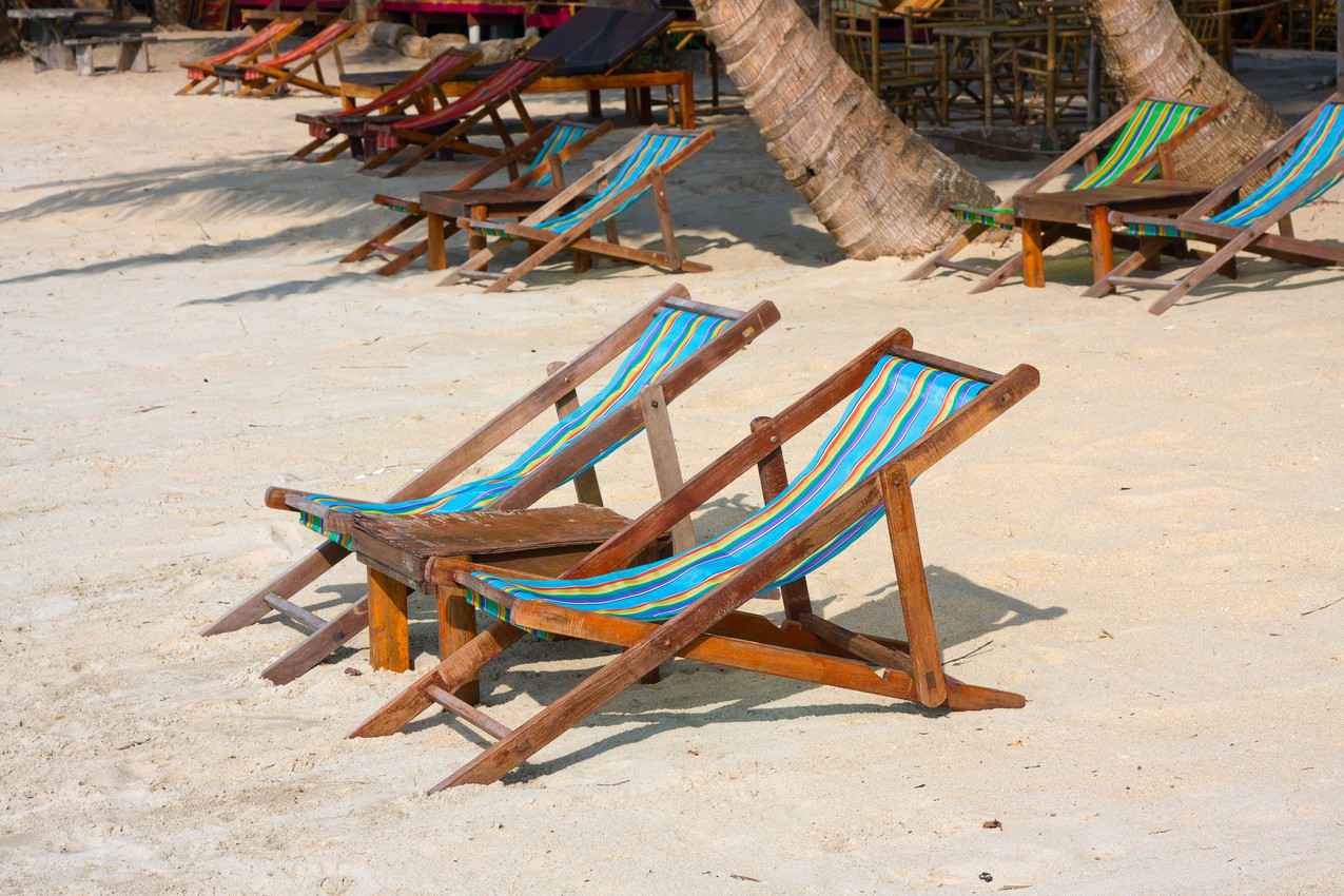 Several lounge chairs along the beach.
