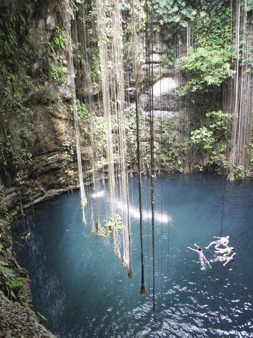 A group of people swimming and playing inside a cenote near Playa Del Carmen.