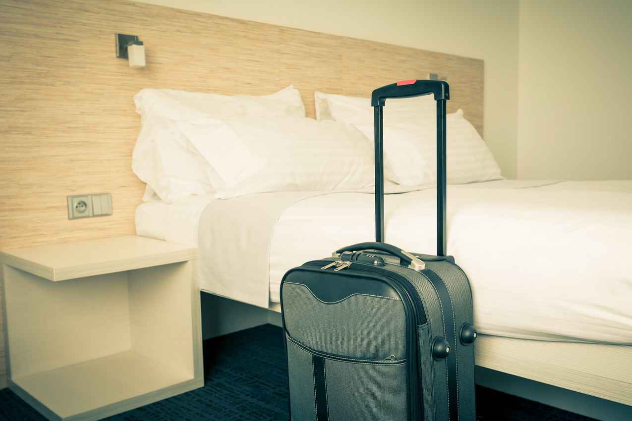 A suitcase waiting to be unpacked in a hotel room.