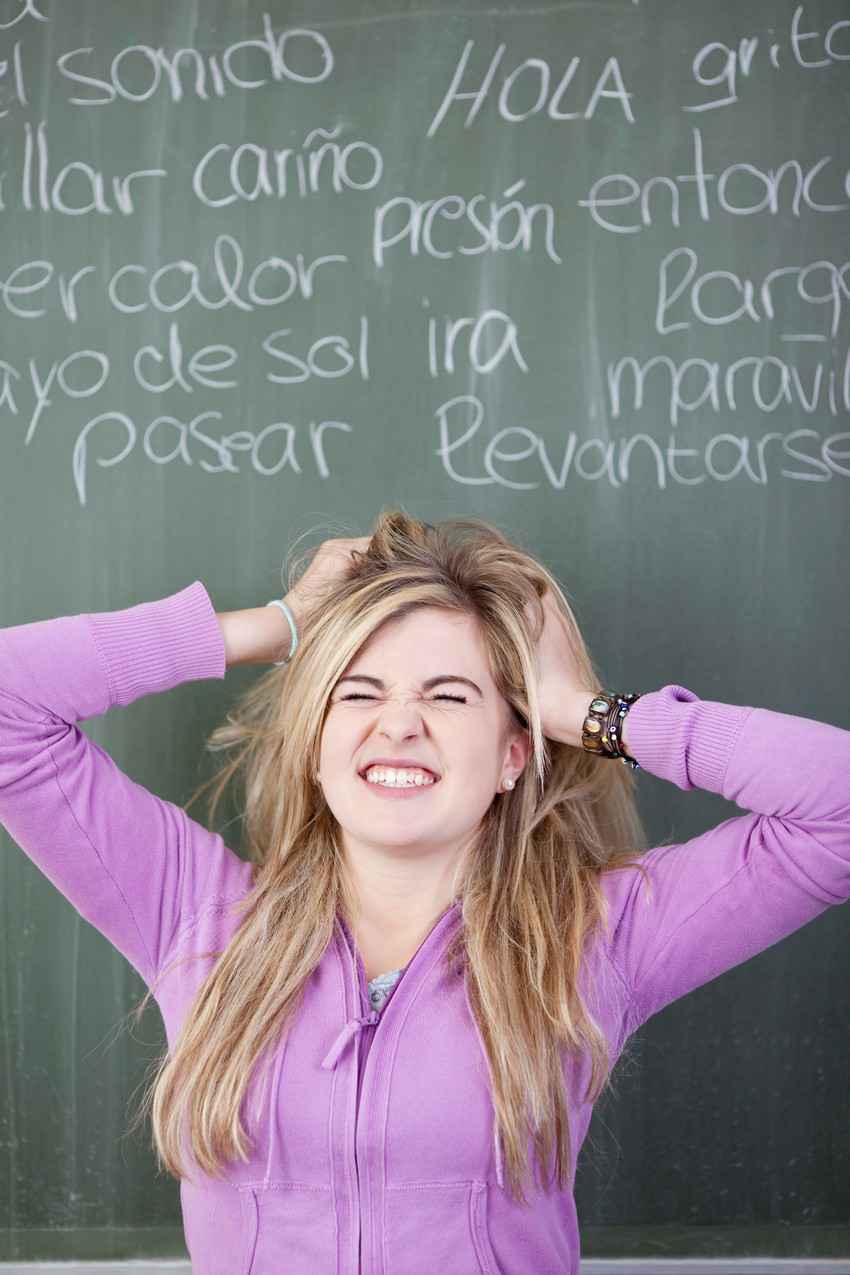 A woman pulling her hair out because she is frustrated while learning a foreign language.