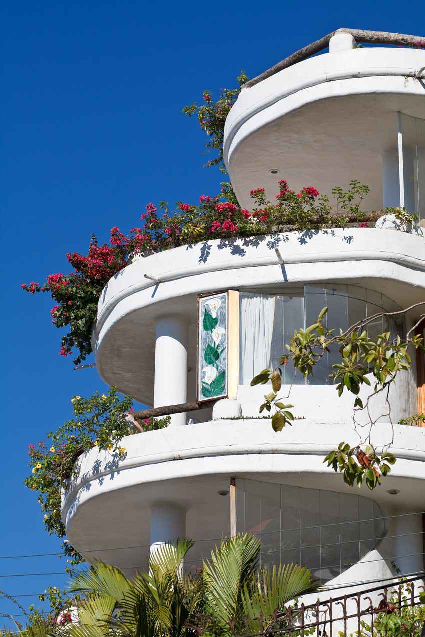 A timeshare for sale with many flowers and round balconies.