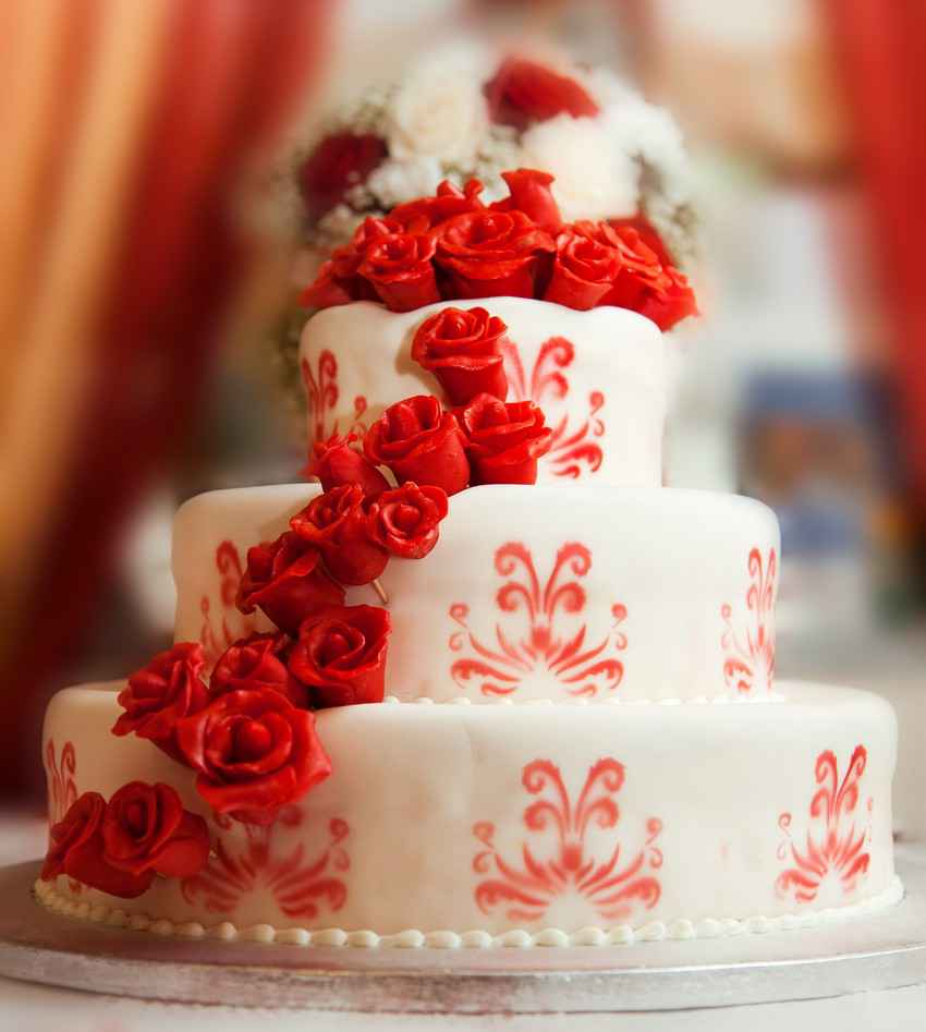 An amazing wedding cake with candy roses all over it.