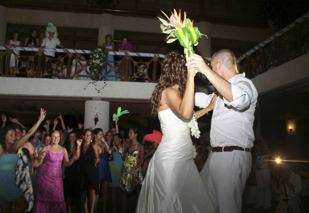 Two recently married couples dancing at a Playa Del Carmen wedding hall.