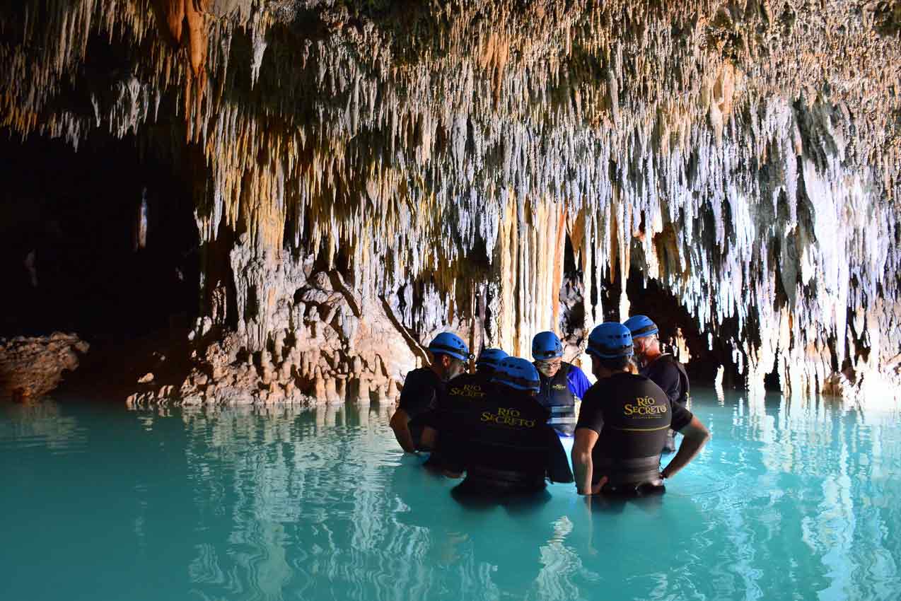 5-tourists-and-1-guide-standing-in-waist-high-water-during-rio-secreto-playa-del-carmen