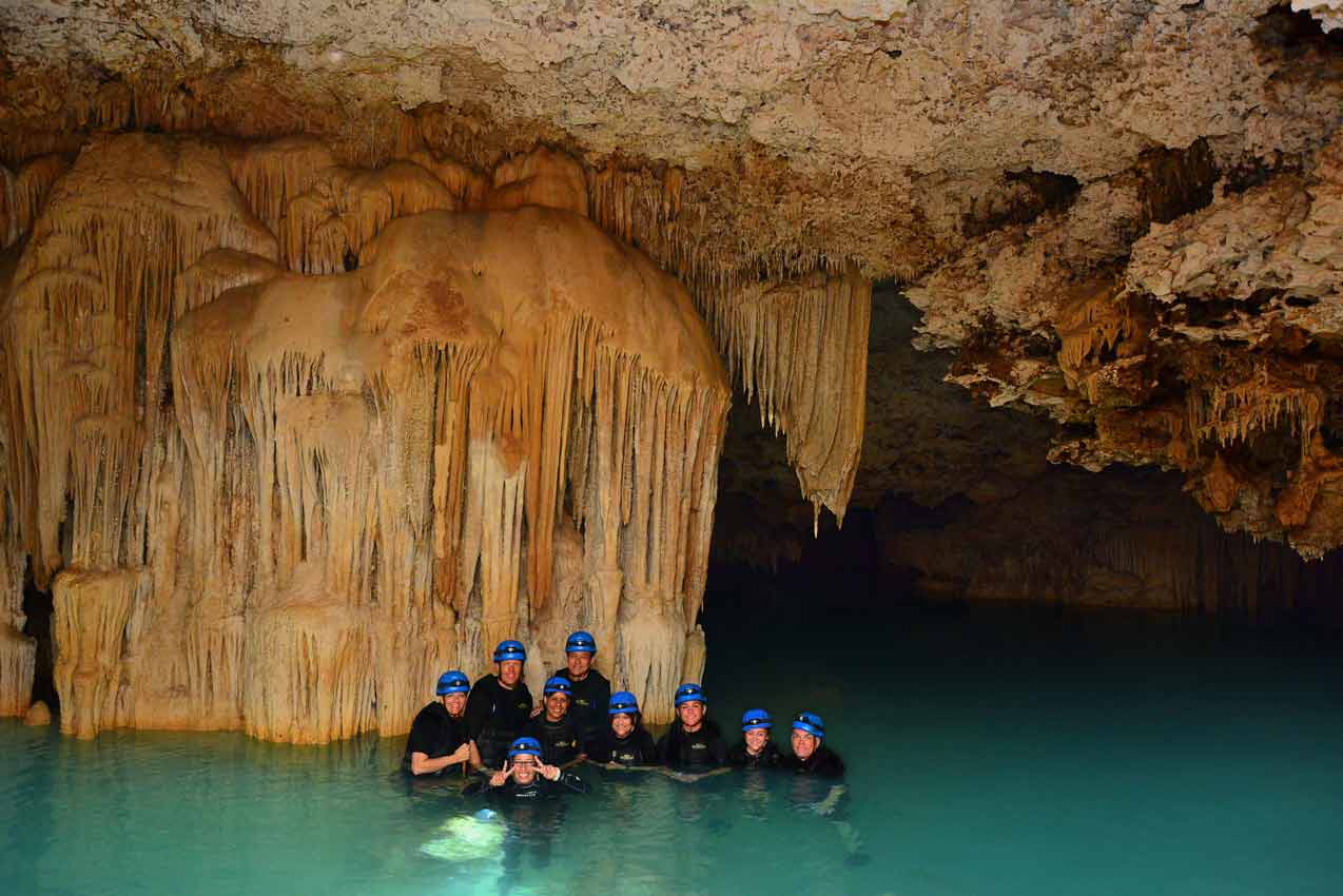 group-of-tourist-in-large-cavern-with-strange-formation-behind-them-during-rio-secreto-tour