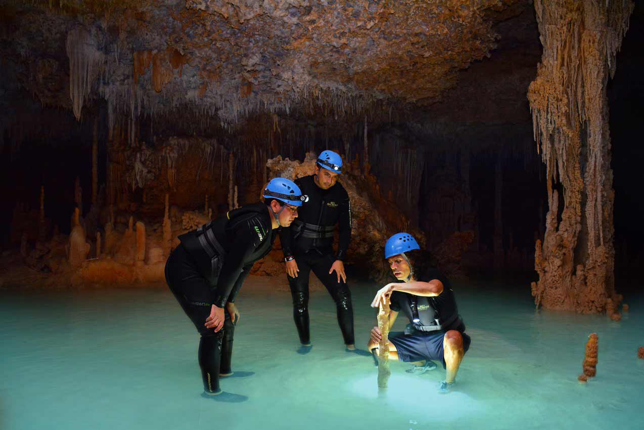 rio-secreto-cancun-guide-teaching-two-tourists-about-water-in-cenote-cave