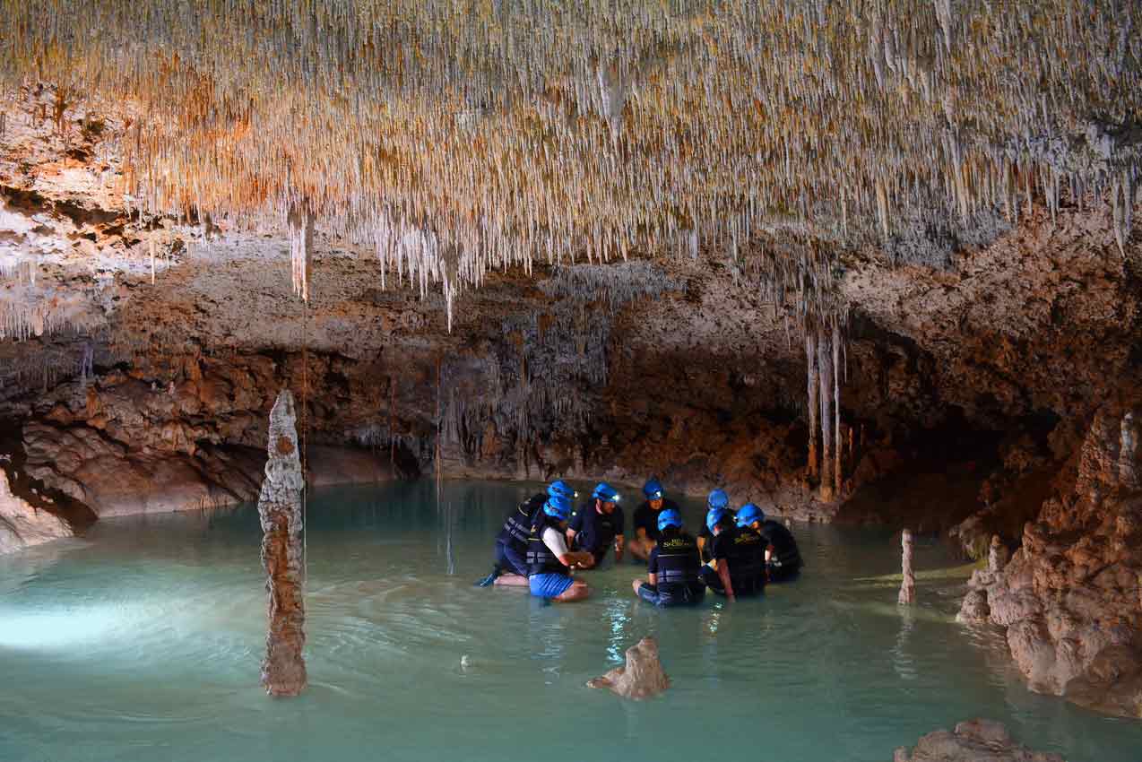rio-secreto-small-group-tour-of-8-people-in-a-shallow-water-hole-filled-with-stalactites-and-stalagmites