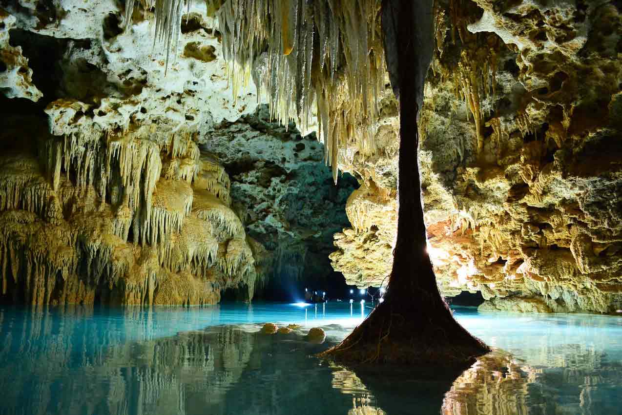 rio-secreto-tour-guide-leading-a-group-of-tourists-through-a-water-filled-cave