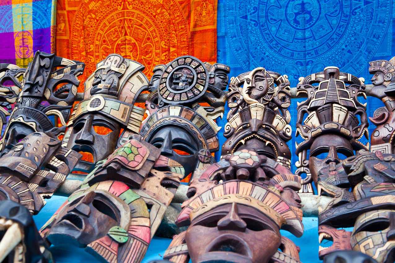 Several amazing and beautiful hand carved wooden Mayan masks for sale on the street.