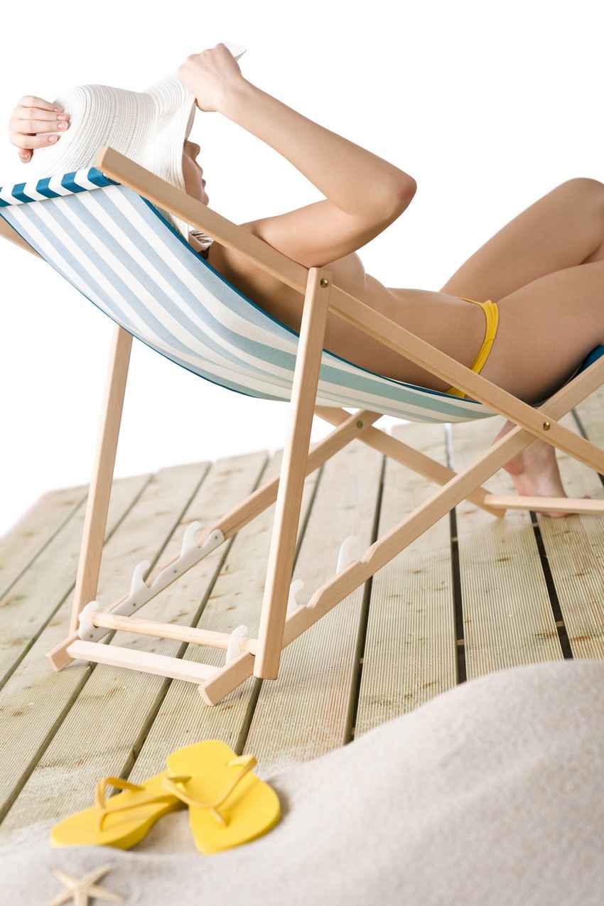 A topless swinger sitting in a beach chair near Playa Del Carmen.