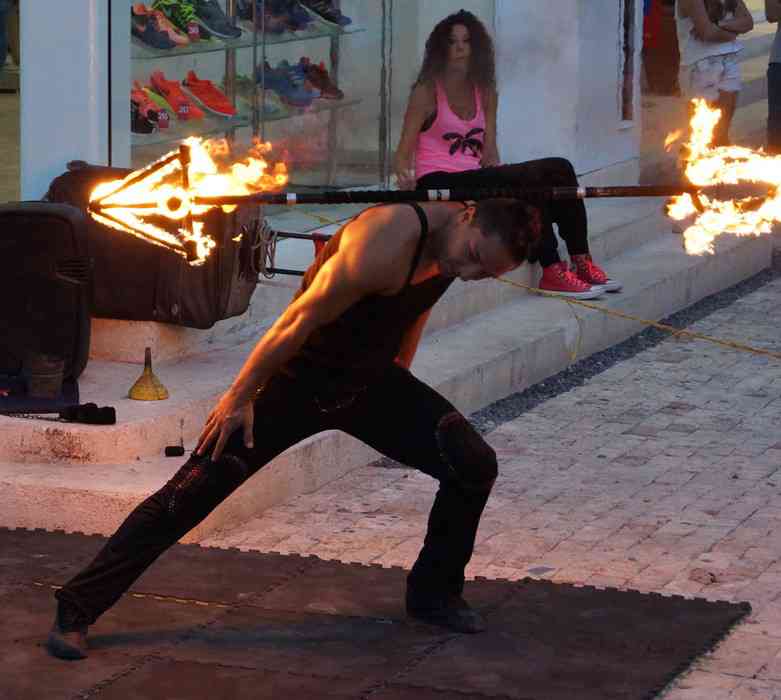 One of the fire dancers with a burning pole around his neck on Fifth Avenue in Playa Del Carmen.