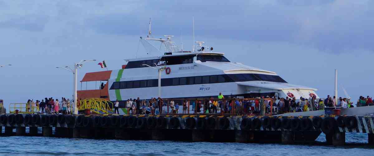 A group of people boarding a ferry boat to Cozumel at a pier in Playa Del Carmen.