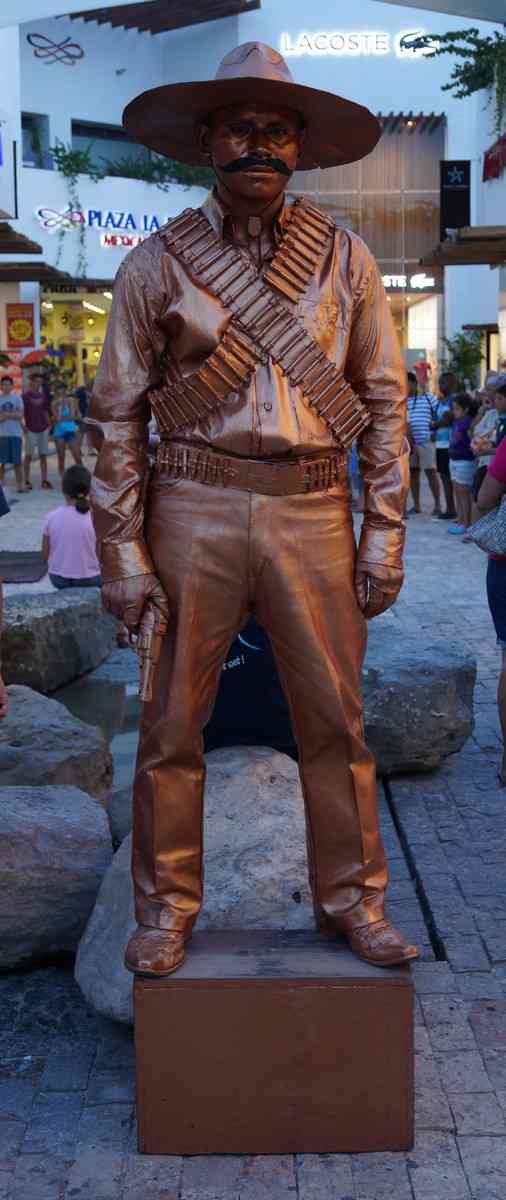 A statue man with a gun on Fifth Avenue in Playa Del Carmen.