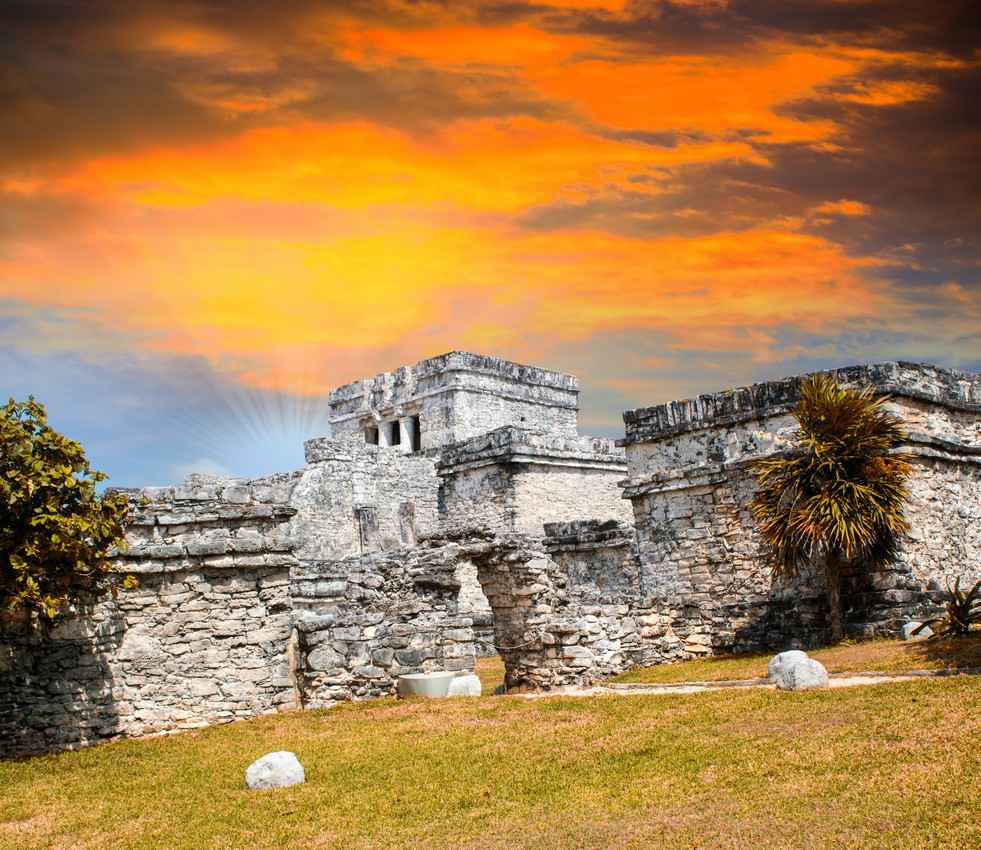 The Mayan ruins at Tulum with a beautiful sunset sky in the background.