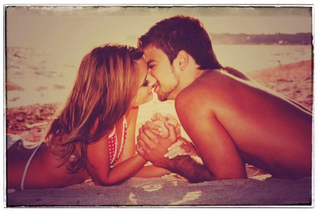 A retro picture of a man and woman kissing on a beach.