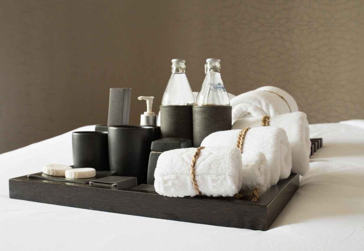 Several bath towels with washcloths and toiletries in a fancy bathroom.