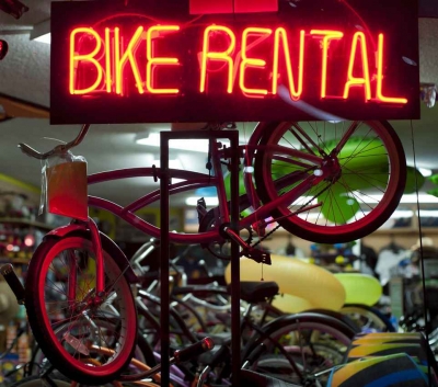 A bike rental neon sign in a shop.
