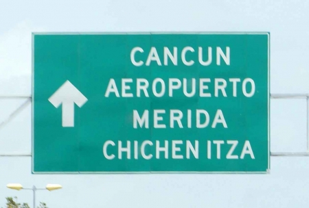 A Cancun airport sign on the freeway.
