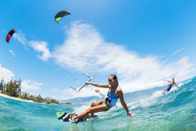 A man and a woman kite boarding in the Caribbean Sea.