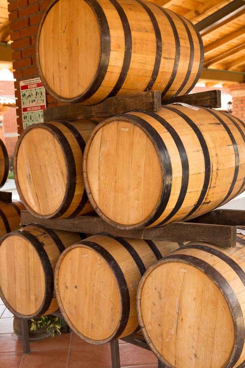 Several barrels filled with aging tequila at a tequila manufacturing plant.