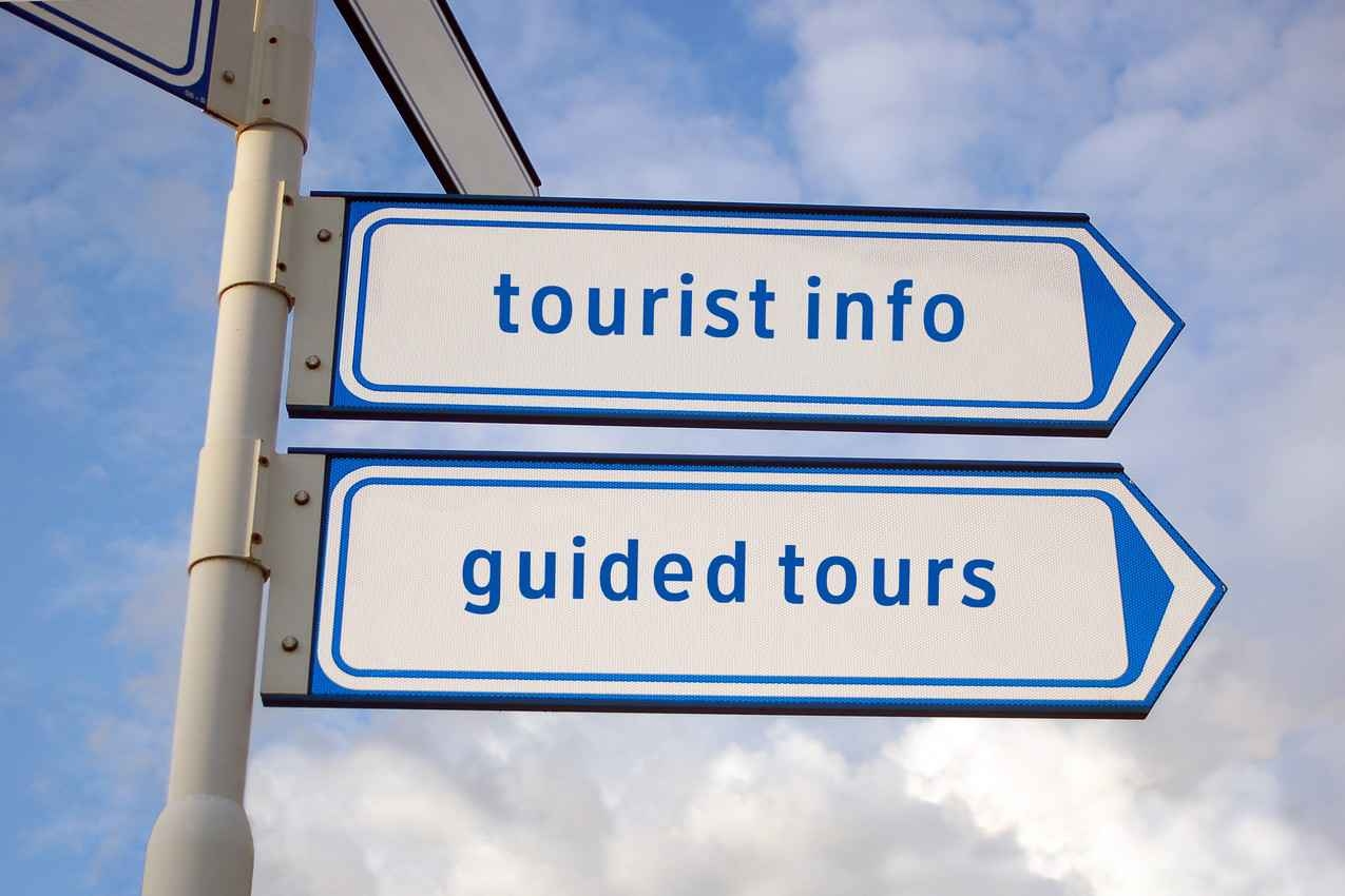 A sign post that says tourist info and guided tours.