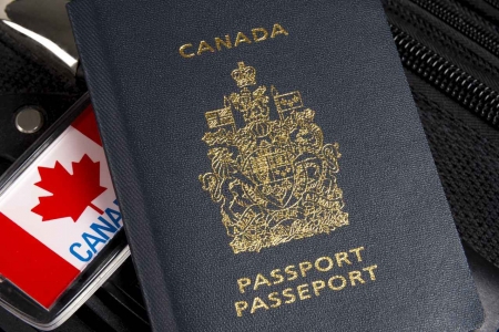 A Canadian passport on top of some luggage.