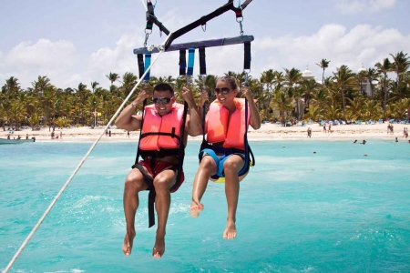 A newlywed couple parasailing close to the beach in Playa Del Carmen.