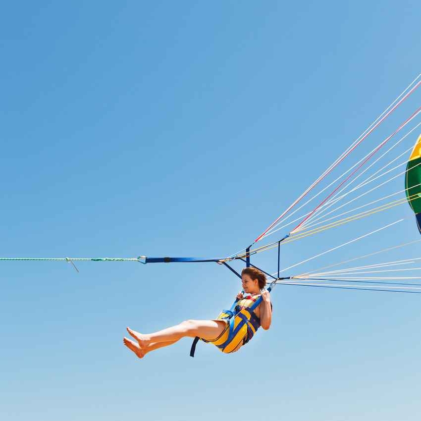 A woman hanging from a parasail.
