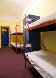 Several bunkbeds in a shared hostel dormitory.