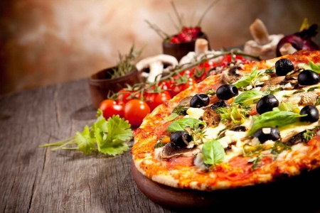 An Italian style pizza with mushrooms, olives, tomatoes, and other herbs.