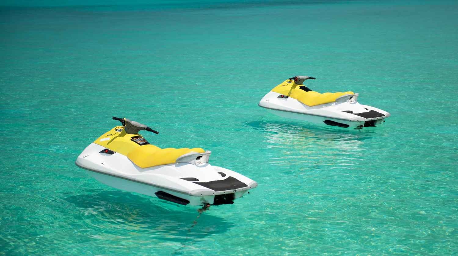Two jet skis in crystal clear water.