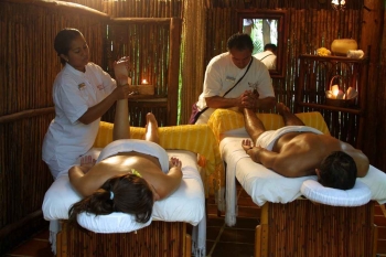 A man and a woman receiving massages at the same time.