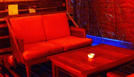 A dimly lit red room in a local Playa Del Carmen bar.
