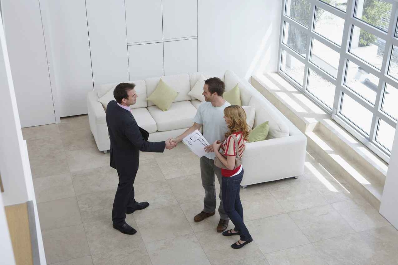 A man and a woman shaking hands with a realtor in a beautiful Playa Del Carmen home.