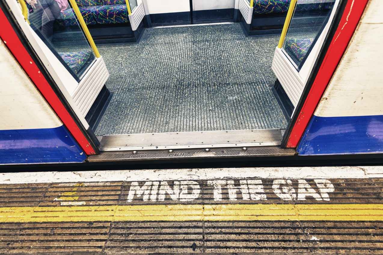 Mind the gap written on the walkway near a subway entrance.