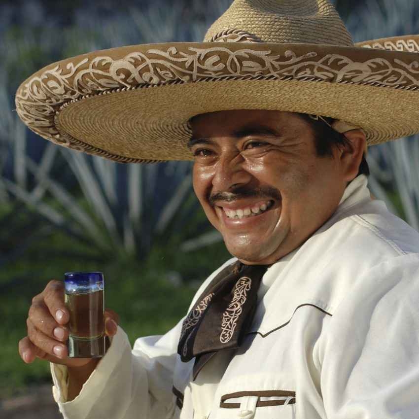A Mexican bozo taking a shot of tequila.